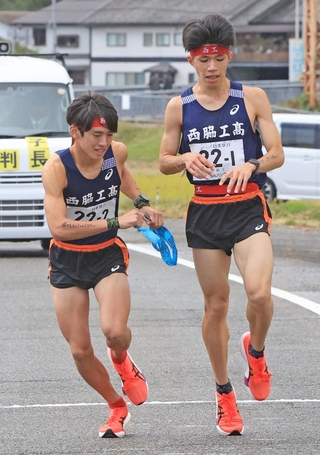 男子・西脇工の１区新妻遼己（右）からたすきを受け取る２区中道琉惺（撮影・丸山桃奈）