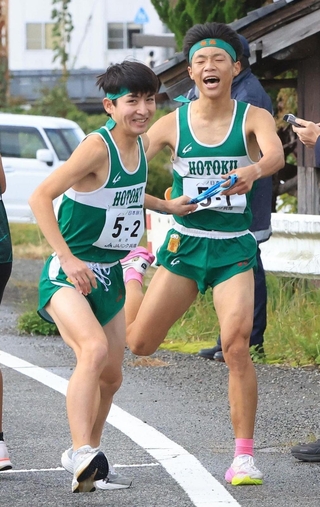 男子・報徳の１区稲葉俊也（右）からたすきを受け取る２区福嶋遙（撮影・丸山桃奈）