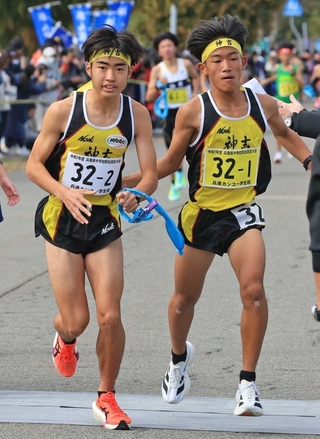 男子・神吉の１区細川晃良（右）からたすきを受け取る２区石塚勇輝（撮影・吉田敦史）