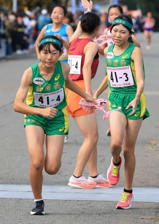 女子・飾磨西の３区有井桃（右）が４区和田心奈にたすきを渡す