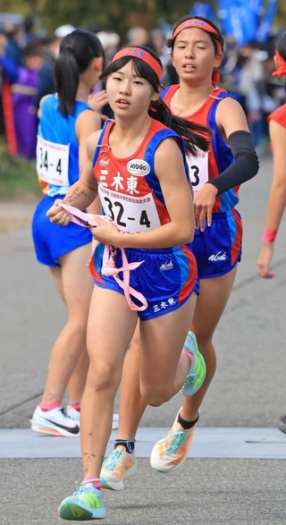 女子・三木東の３区上田芽依（右）からたすきを受け取る４区大塚もえ