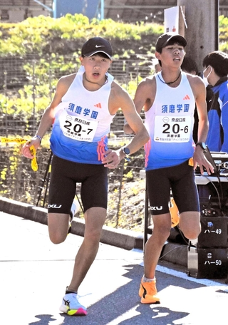 男子・須磨学園のアンカー酒上航熙（左）にたすきをつなぐ６区上山宙大＝16日午後、奈良県宇陀市