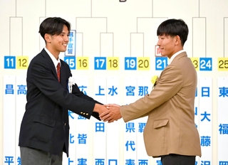 第１０４回全国高校サッカー選手権で対戦が決まり、握手を交わす前橋育英の竹ノ谷主将（左）と神戸弘陵の今井主将＝17日、東京都港区