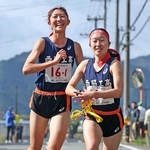 女子・西脇工の１区山本心愛（左）からたすきを受ける２区藤田このあ（撮影・鈴木雅之）