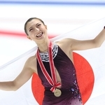 女子で２連覇し、日の丸を背負って笑顔を見せる坂本花織＝東和薬品ラクタブドーム（撮影・中田匡峻）