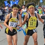 男子・神吉の１区細川晃良（右）からたすきを受け取る２区石塚勇輝（撮影・吉田敦史）