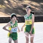 女子・飾磨西の３区有井桃（左）が２区田上奏からたすきを受け取る