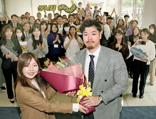 歓迎の花束を受け取る佐藤輝明内野手（手前右）＝１日午後、神戸市中央区（撮影・田中太一）