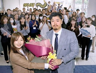 歓迎の花束を受け取る佐藤輝明内野手（手前右）＝１日午後、神戸市中央区（撮影・田中太一）