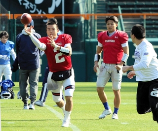 甲子園ボウル前の練習で体を動かす（左から）関学大ＱＢの星野秀と弟の星野太＝11日、西宮市の甲子園球場