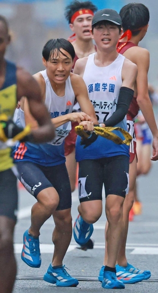 男子・須磨学園の１区藤岡孝太郎（右）からたすきを受け取る２区足立昌汰（撮影・鈴木雅之）