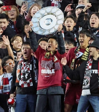 Ｊ１連覇を決め、スタンドでシャーレを掲げる吉田孝行監督＝２０２４年１２月８日、ノエビアスタジアム神戸