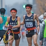 男子・西脇工の１区新妻遼己（右）からたすきを受ける２区岩崎奏（撮影・鈴木雅之）