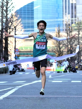 箱根駅伝３連覇を飾るゴールテープを切る青学大のアンカー折田壮太＝東京・大手町