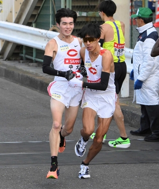 箱根駅伝でたすきをつなぐ中大・藤田大智（左）＝２日、横浜市内