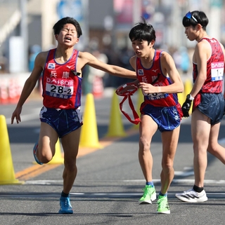 兵庫２区の佐藤颯流（左）からたすきを受け取る３区長嶋幸宝＝１８日午後、広島市内（撮影・丸山桃奈）