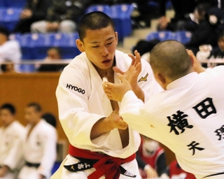 男子６６キロ級決勝　組手を争う神港学園の藤村立志（左）