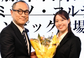 五輪出場が決まり、競技スキー部の渡辺昌史部長（左）から花束を受け取る藤木日菜＝西宮市内