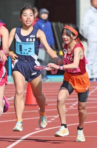 女子・神戸市垂水区２区の明比梨々香（左）からたすきを受け取る３区の森貞帆加（撮影・丸山桃奈）