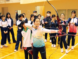上原瑠果（手前）の試射を間近で見学する中高生ら＝神戸市西区、兵庫県立障害者スポーツ交流館