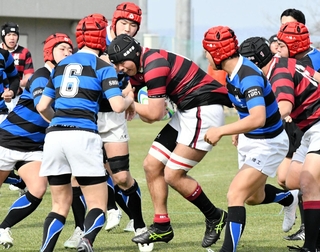 報徳－八幡工　相手に囲まれながらも突破を図る報徳のロック清野（中央）＝京都府宇治市、山城総合運動公園球技場