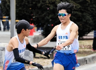 男子・須磨学園Ａの３区梅田大陸（右）がトップを奪い、４区上山宙大へリレー