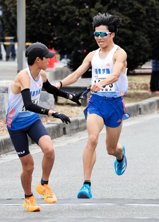 男子・須磨学園Ａの３区梅田大陸（右）がトップを奪い、４区上山宙大へリレー