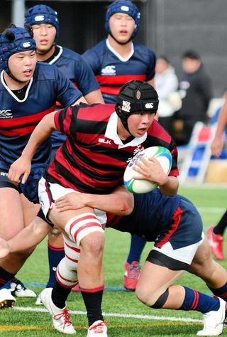 報徳－常翔学園　タックルを受けながら前進する報徳のロック前里主将 