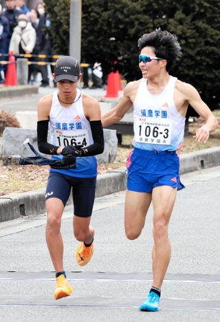 男子の須磨学園Ａ３区梅田大陸（右）がトップを奪い、４区上山宙大へリレー＝西脇市