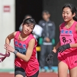 尼崎市３区の関口花奈（右）からたすきを受け取る４区の久能皐央＝三木市志染町三津田、三木総合防災公園陸上競技場（撮影・丸山桃奈）