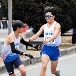 男子・須磨学園Ａの３区梅田大陸（右）がトップを奪い、４区上山宙大へリレー