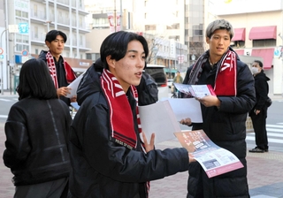 通行人にチラシを配って来場を呼びかける神戸の浜崎（中央）、小松（右）、山田（左奥）＝神戸市中央区