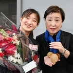 幼少期から指導を仰いだ中野園子コーチに金メダルをかける坂本花織＝３月３１日午後、大阪府泉佐野市の関西空港（撮影・大田将之）