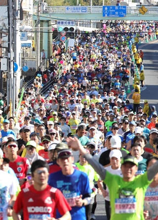 ＪＲ塩屋駅前を走るランナーたち＝神戸市垂水区