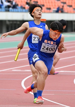 高校男子１６００メートルリレー決勝　滝川第二の１走大段璃空（奥）が２走の知識航作にバトンをつなぐ（撮影・風斗雅博）