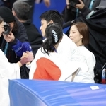 ミラノ・コルティナ冬季五輪で女子銀メダルを獲得し、三浦璃来（右）と木原龍一（中央奥）らからねぎらわれる坂本花織（左）＝２月、ミラノ