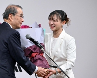 家次恒シスメックス会長（左）から花束を受け取る坂本花織＝１３日午前、神戸市中央区港島中町６、神戸ポートピアホテル（撮影・斎藤雅志）