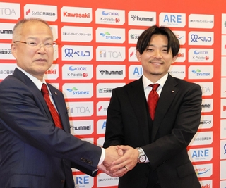 ＩＮＡＣ神戸の金子文雄会長（左）と握手を交わす阿部浩之新社長＝神戸市東灘区