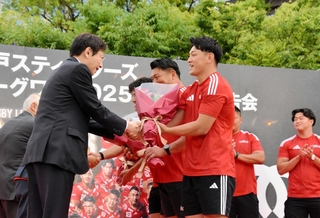 リーグワンの優勝報告会で、神戸市の久元喜造市長（前列左）らから花束を受け取る李承信（同右）ら神戸の選手たち＝神戸市中央区、東遊園地