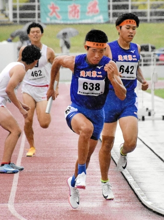 陸上の近畿選手権男子１６００メートルリレー決勝で、滝川第二高の３走・知識航作（右橋）からバトンを受け取るアンカー平岡大輔＝和歌山市、紀三井寺公園陸上競技場