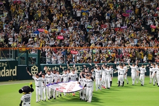 リーグ優勝のペナントを手にグラウンドを一周する阪神ナイン＝６日夜、西宮市の甲子園球場（撮影・笠原次郎）