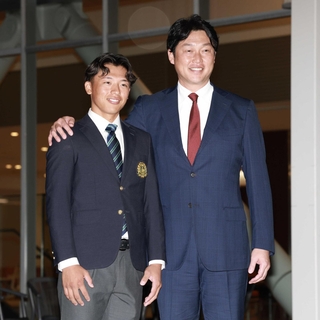 広島にドラフト１位指名され、新井貴浩監督（右）からあいさつされる亜大・山里宝＝２２日夜、東京都武蔵野市（撮影・伊藤笙子）