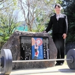 母校に設置された記念碑とともに笑顔を見せる八木かなえさん＝須磨友が丘高