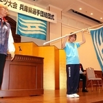 兵庫県選手団の増田和茂団長（左）から県旗を受け取った旗手の岩佐桜星＝神戸市中央区、県公館