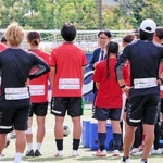 アイナックフットボールクラブ常務取締役の大塚健護氏（中央奥）から新スタジアム計画の説明を受ける選手ら＝神戸市東灘区、神戸レディースフットボールセンター