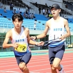 地区予選会でたすきをつなぐ男子・須磨学園の大柿司（右）と東海成＝三木総合防災公園陸上競技場