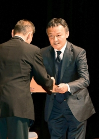 功労者表彰で賞状を受け取る三牧一雅氏