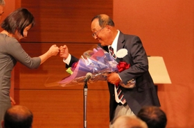 監督勇退の花束を受け取り、グータッチを交わす関学の広岡総監督（右）＝神戸ポートピアホテル