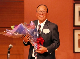 花束を受け取り、笑顔を見せる関学の広岡総監督＝神戸ポートピアホテル
