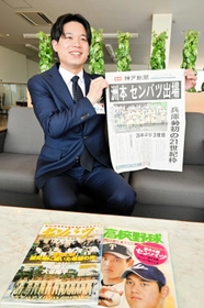 １１年前の神戸新聞号外を手に笑顔の飯田卓也さん＝淡路市役所